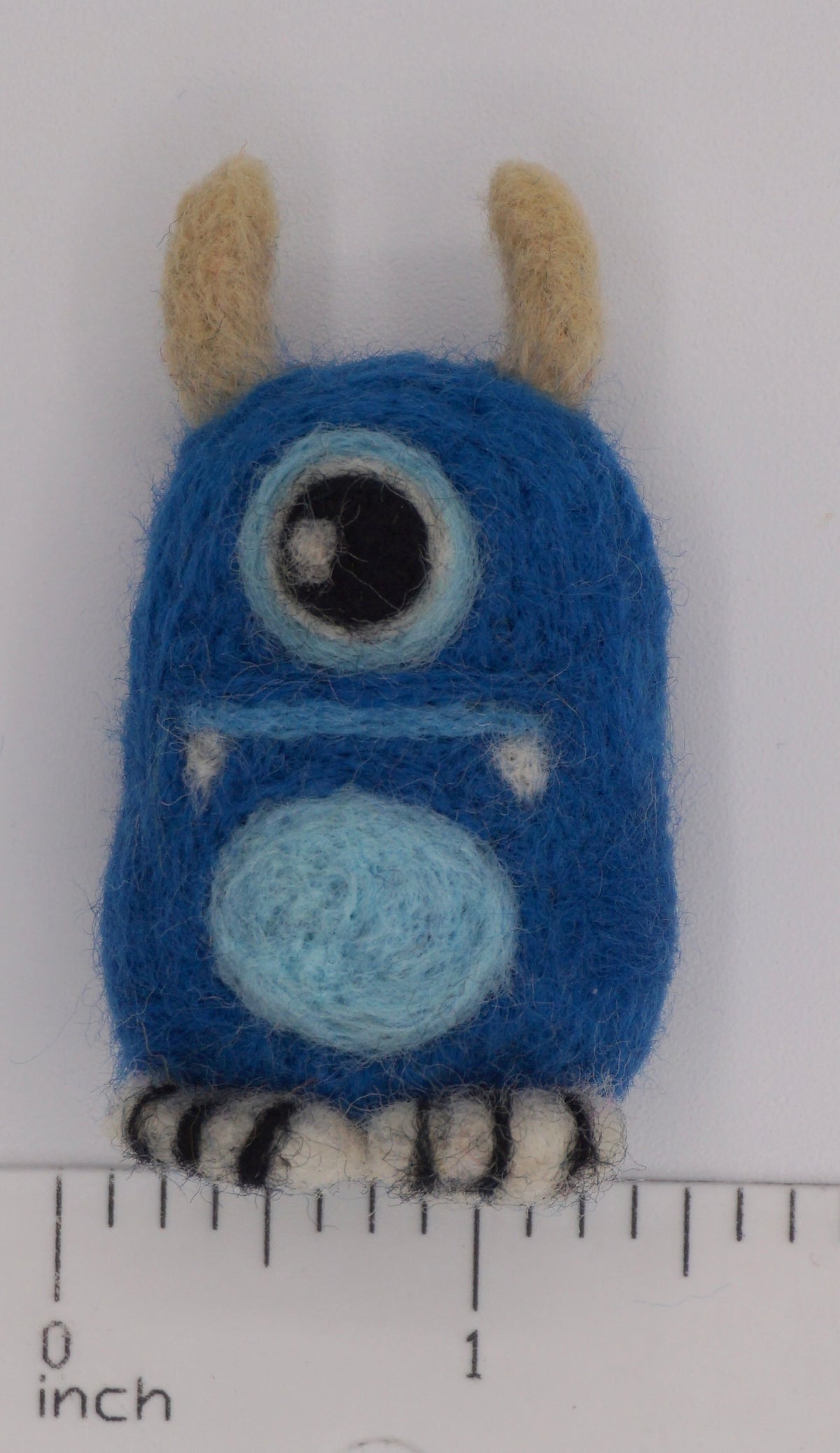 Blue Monster Felt Toy showing the width of toy next to ruler. 