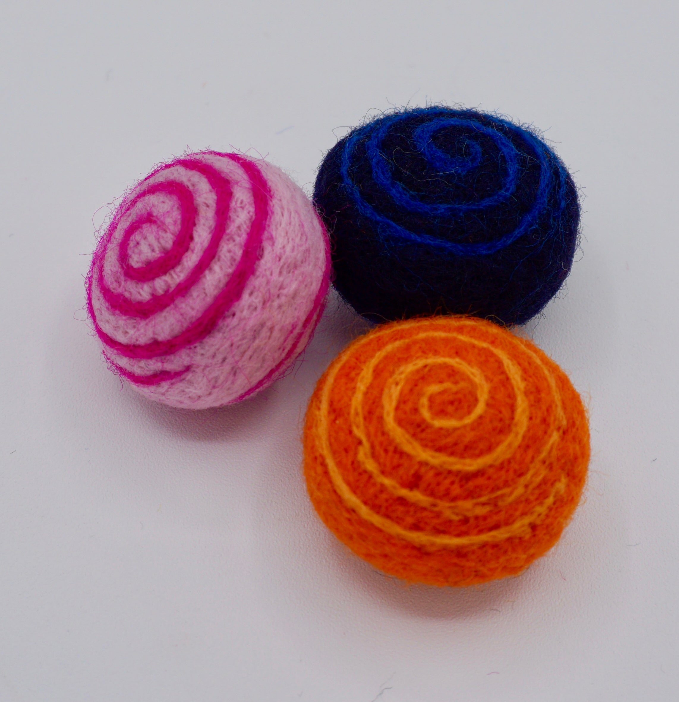 Trio of Swirly Cat Toys in pink, orange and deep blue. 